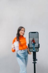 Kreatör filmas med smartphone på stativ mot neutral bakgrund